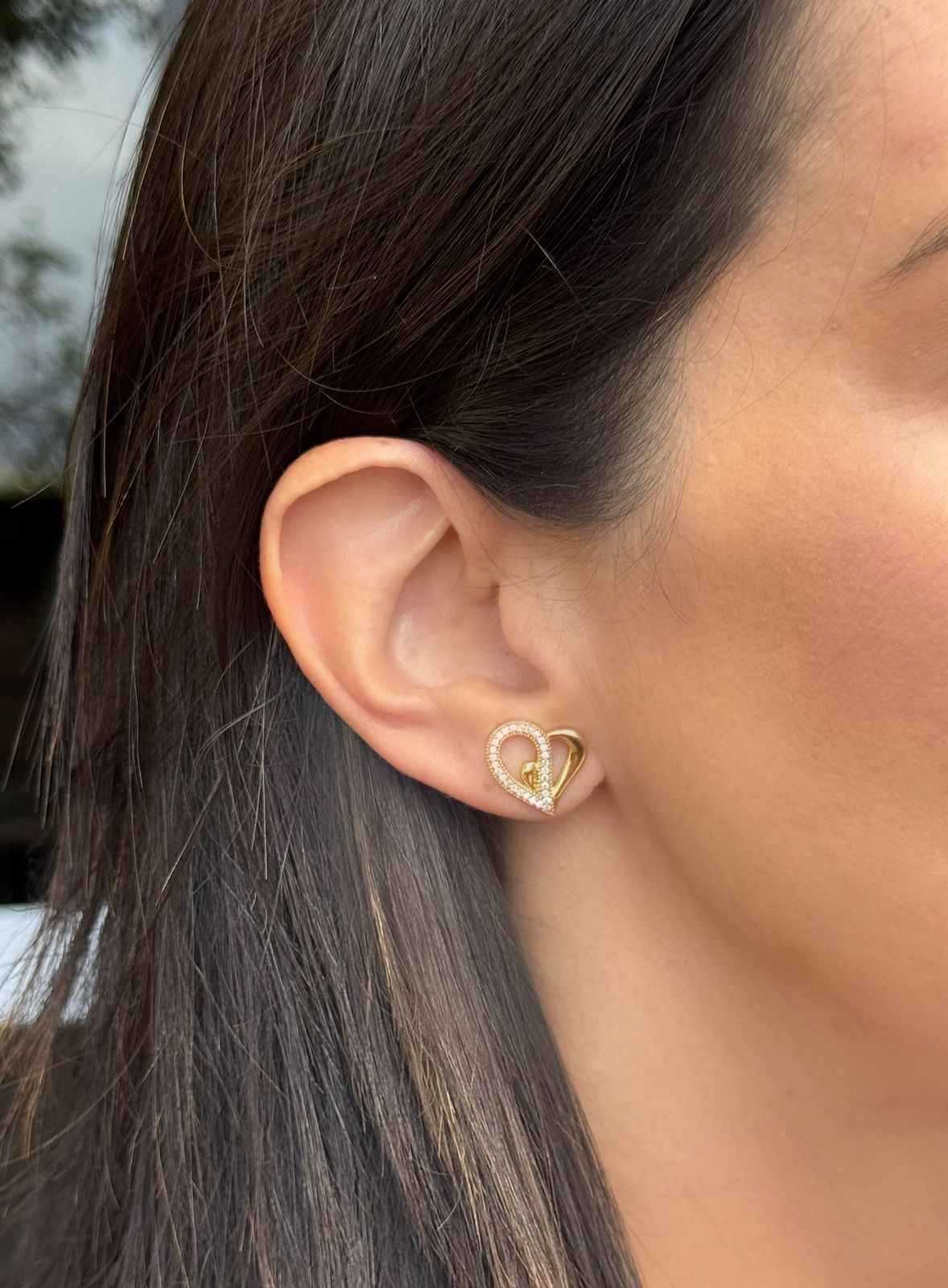 Brinco coração vazado metade cravejado com zircônias em banho de ouro 18k