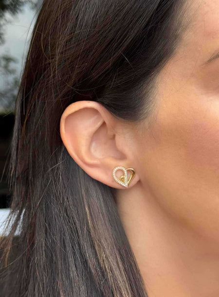 Brinco coração vazado metade cravejado com zircônias em banho de ouro 18k